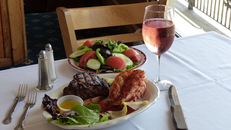Steak and lobster with salad and glass of rose wine